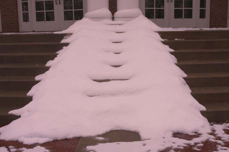 a snow on stairs outside a building