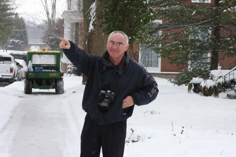 a man pointing at something in the snow
