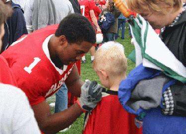a football player helping a young boy