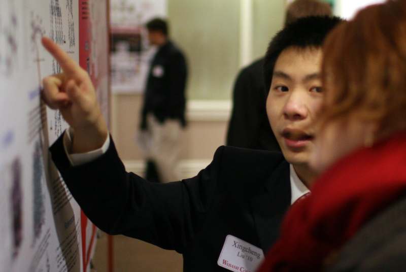 a man pointing at a poster