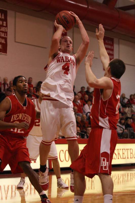 a basketball player in a red uniform jumping to shoot a ball