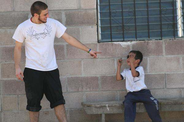 a man pointing at a boy's face