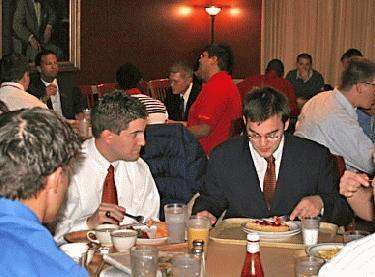 a group of men eating at a restaurant