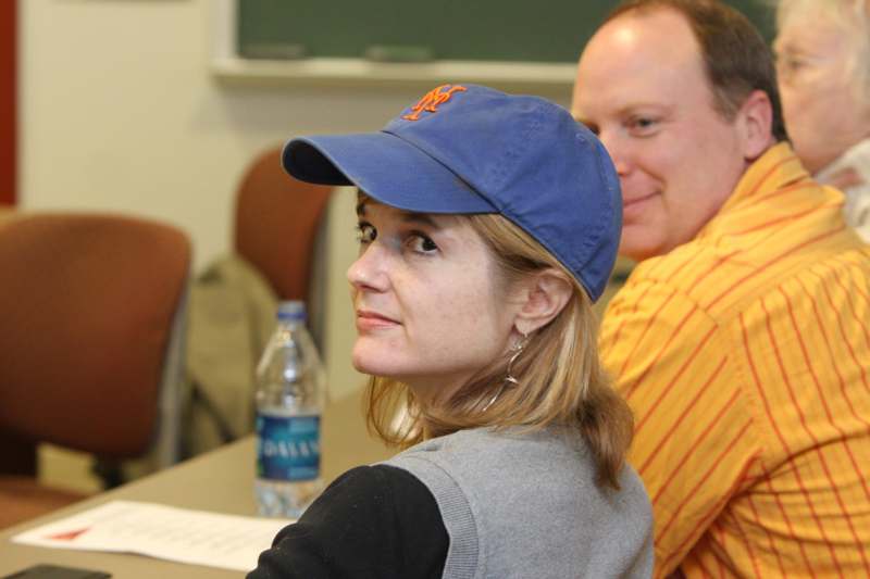a woman wearing a blue hat and a man sitting at a table