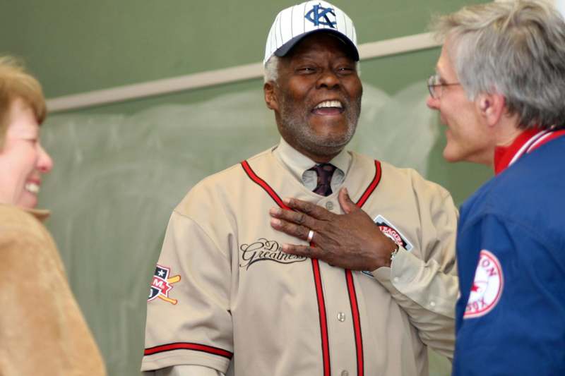 a man laughing while wearing a baseball uniform