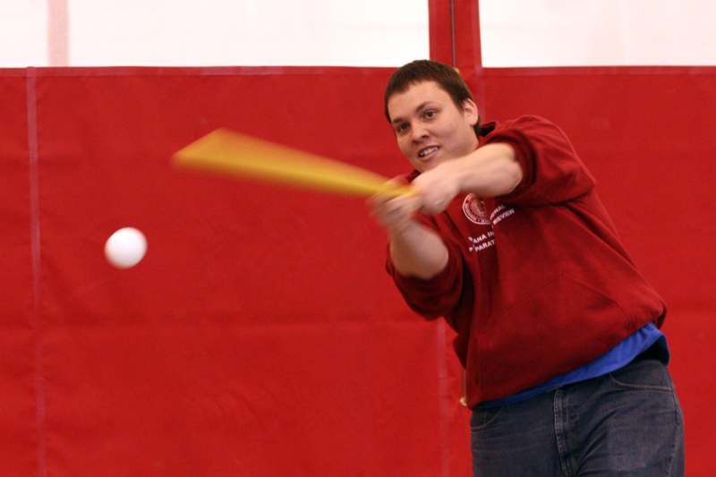 a man hitting a ball with a bat