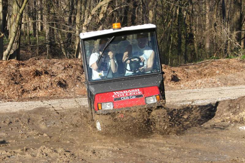 a vehicle driving through a mud puddle