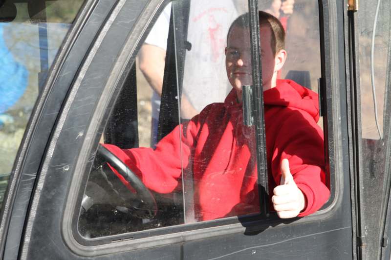 a man in a red jacket sitting in a truck