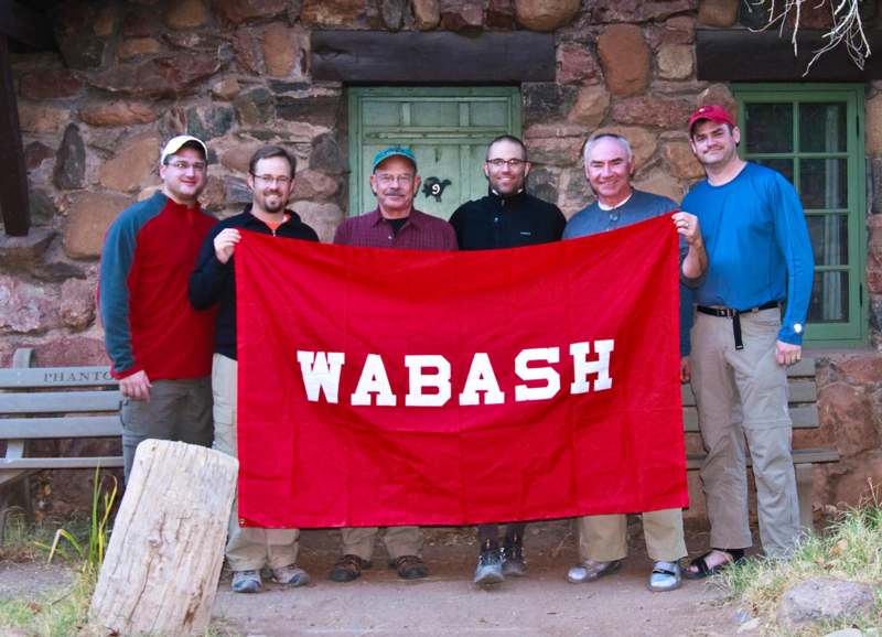 a group of men holding a red banner