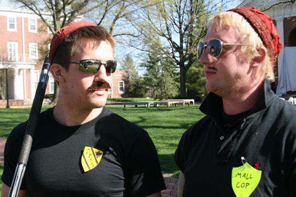 two men wearing sunglasses and a hat with a mustache