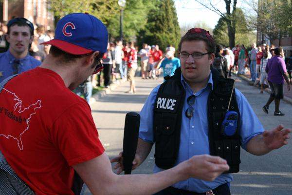 a man in a red shirt and blue hat talking to a man in a red shirt