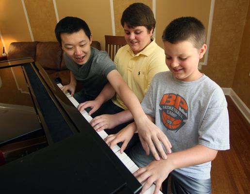 a group of boys playing piano