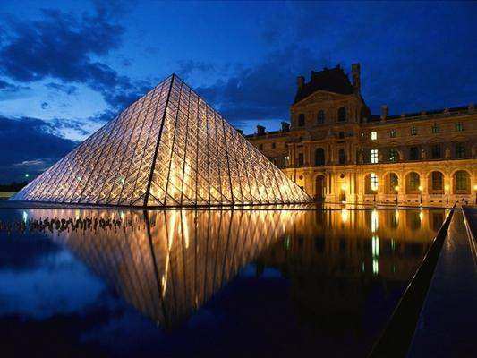a glass pyramid in front of Louvre