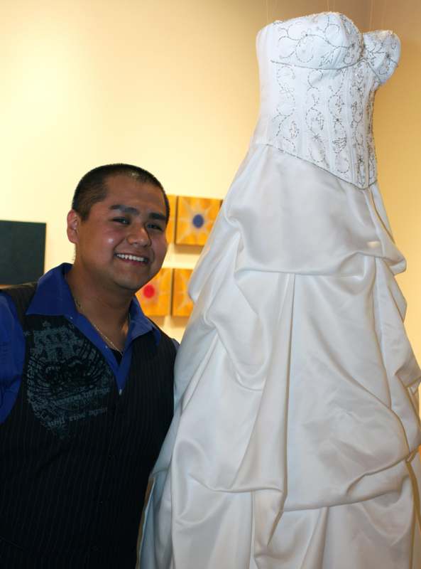 a man standing next to a wedding dress