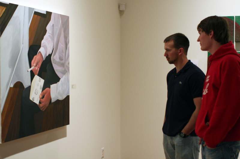 a group of people looking at a painting on a wall