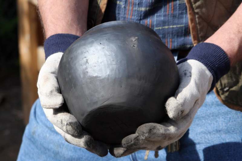 a person holding a round black object