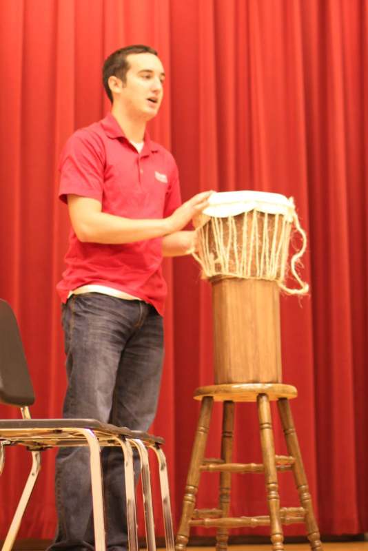 a man standing on a stool with a drum
