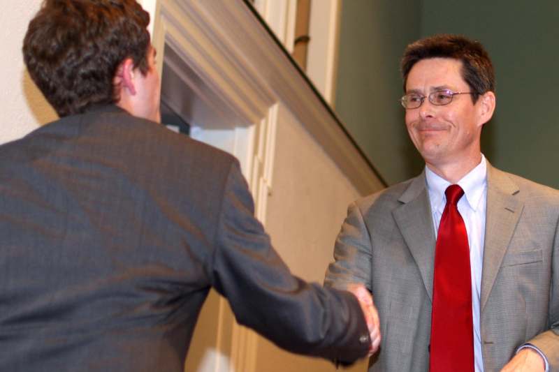 a man in a suit shaking hands with another man