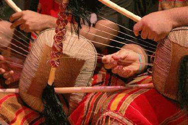 a close-up of a man playing a traditional instrument