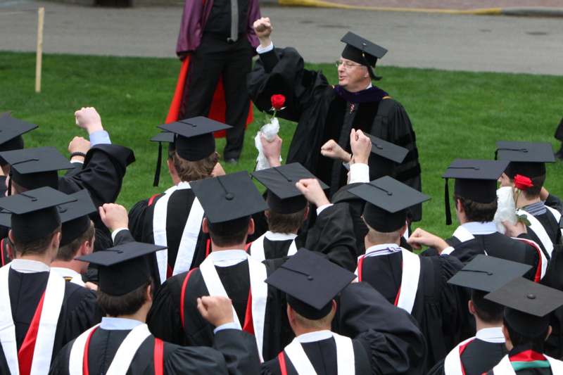 a group of graduates raising their hands