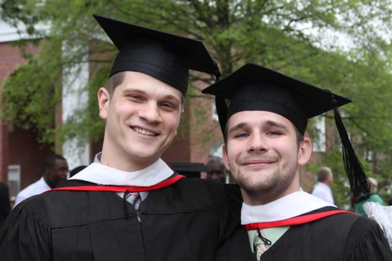 two men in graduation gowns and caps