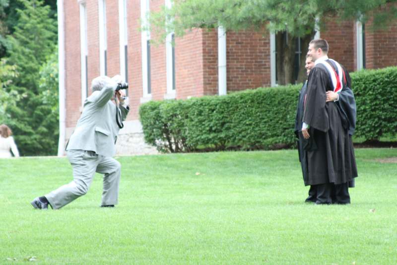 a man taking a picture of a man in a robe
