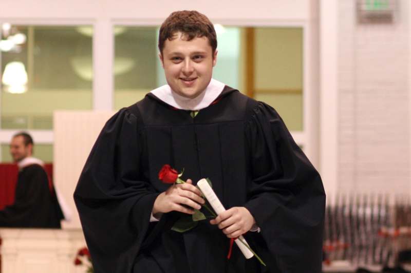 a man in a black robe holding a rose