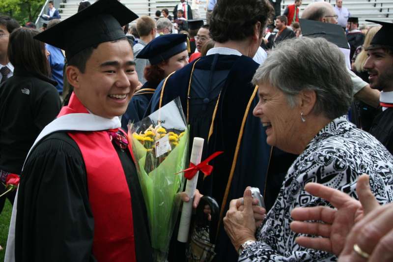 a man in cap and gown holding flowers and a woman in cap and gown
