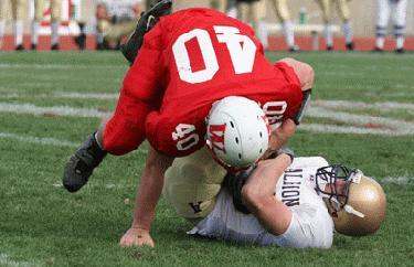a football player in a red uniform wrestling another player in a red uniform