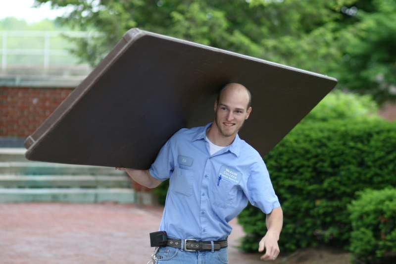 a man carrying a mattress