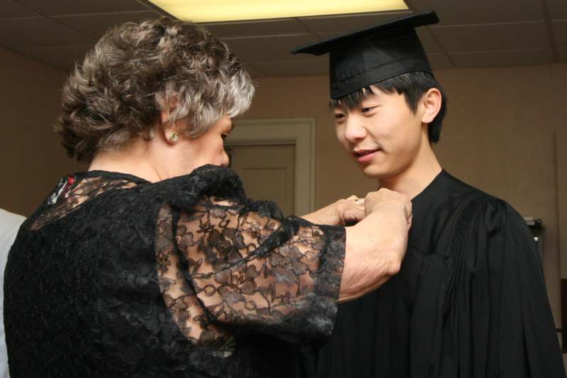 a woman fixing a graduation gown