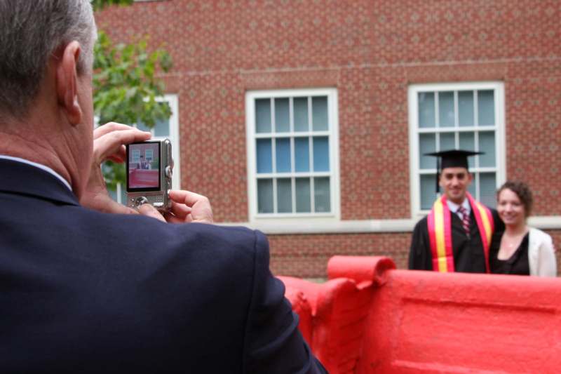 a man taking a picture of a man in a graduation cap