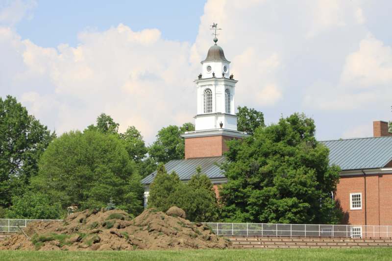 a building with a tower and a pile of dirt