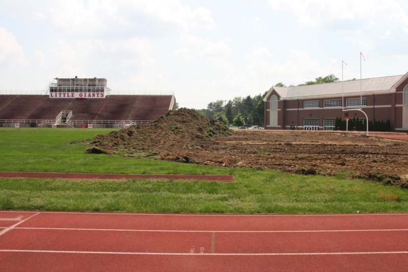 a stadium with a dirt mound and a building