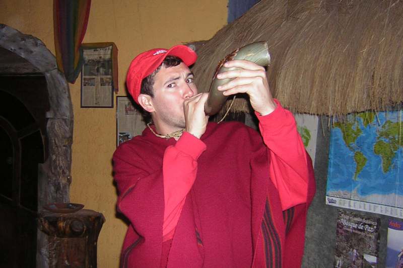 a man in a red hat blowing a horn