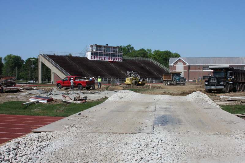 a construction site with a stadium and construction equipment