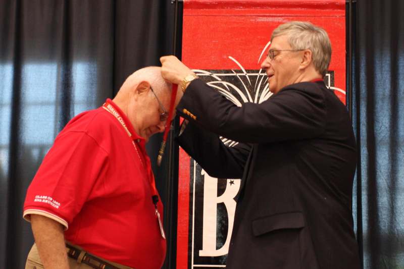a man putting a medal on another man's head