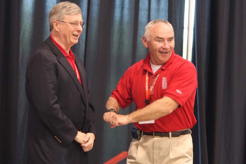 a man in a red shirt shaking hands with another man