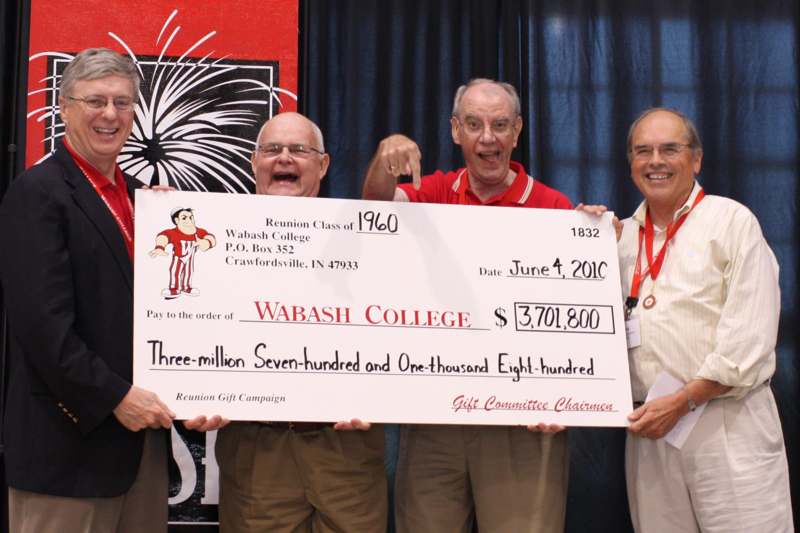 a group of men holding a large check
