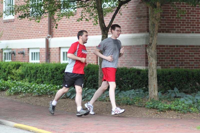 two men running on a sidewalk