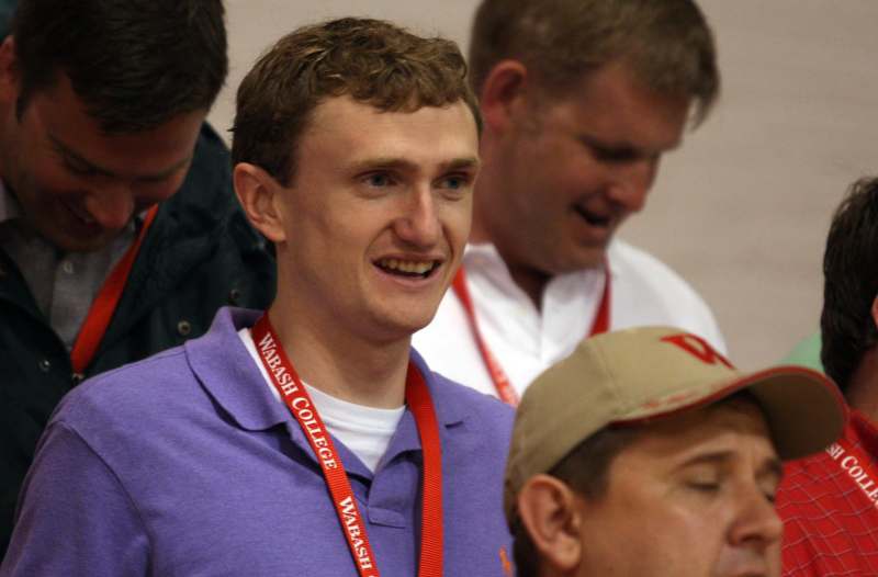 a man wearing a lanyard and smiling