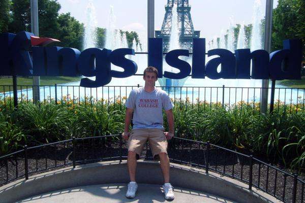 a man sitting in front of a sign