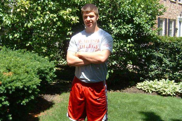a man standing in a yard with his arms crossed