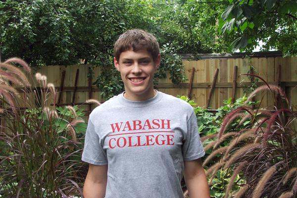 a man smiling in a garden