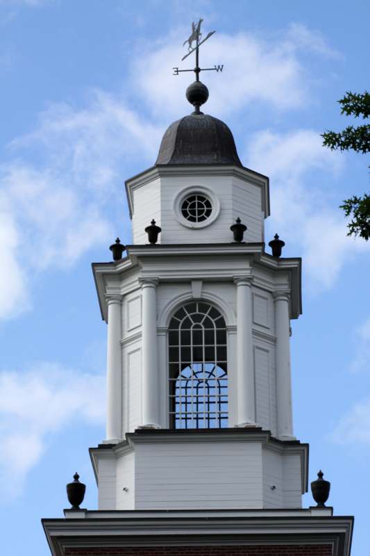 a white tower with a dome and a cross on top