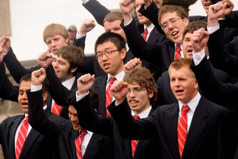 a group of men in suits with their arms raised