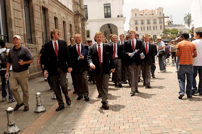 a group of men in suits walking down a street