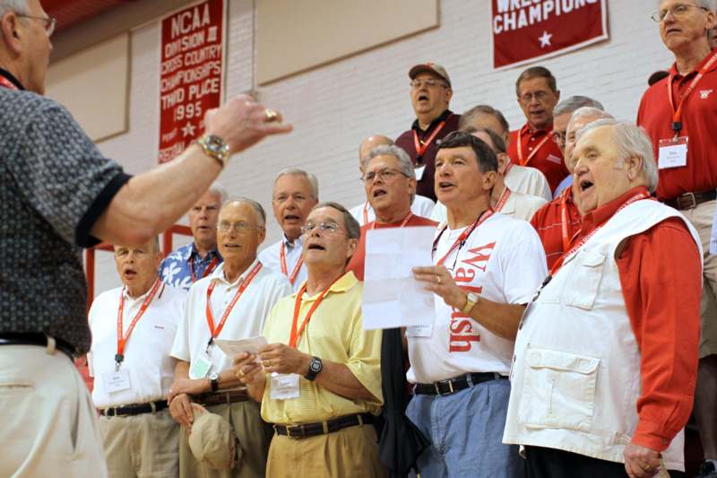 a group of men singing in a gym
