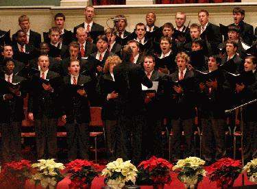 a choir performing in front of a man singing