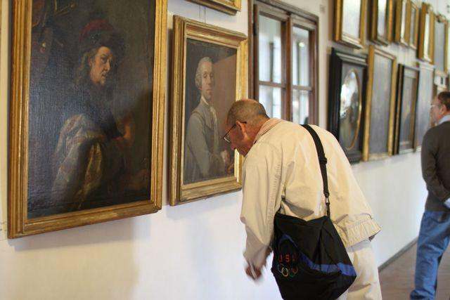 a man looking at a painting on the wall